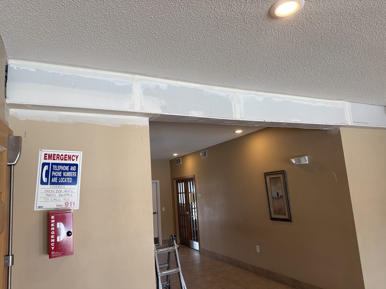 Lobby soffit with newly hung drywall, taped and coated seams ready for texture in a commercial building entry