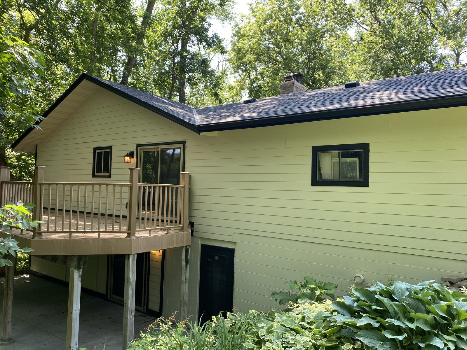 Rear elevation of a Twin Cities home freshly painted sage green with crisp black window and fascia trim