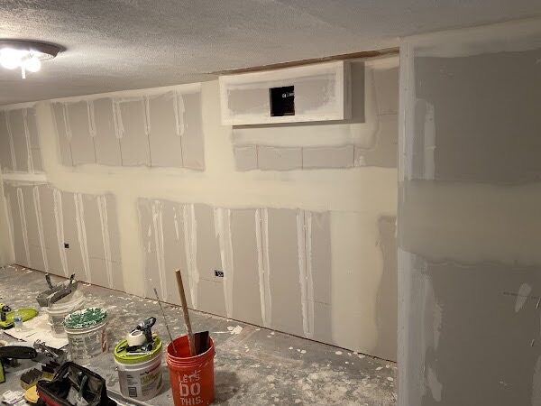 Basement drywall taped and mudded with a framed opening for a mechanical access panel