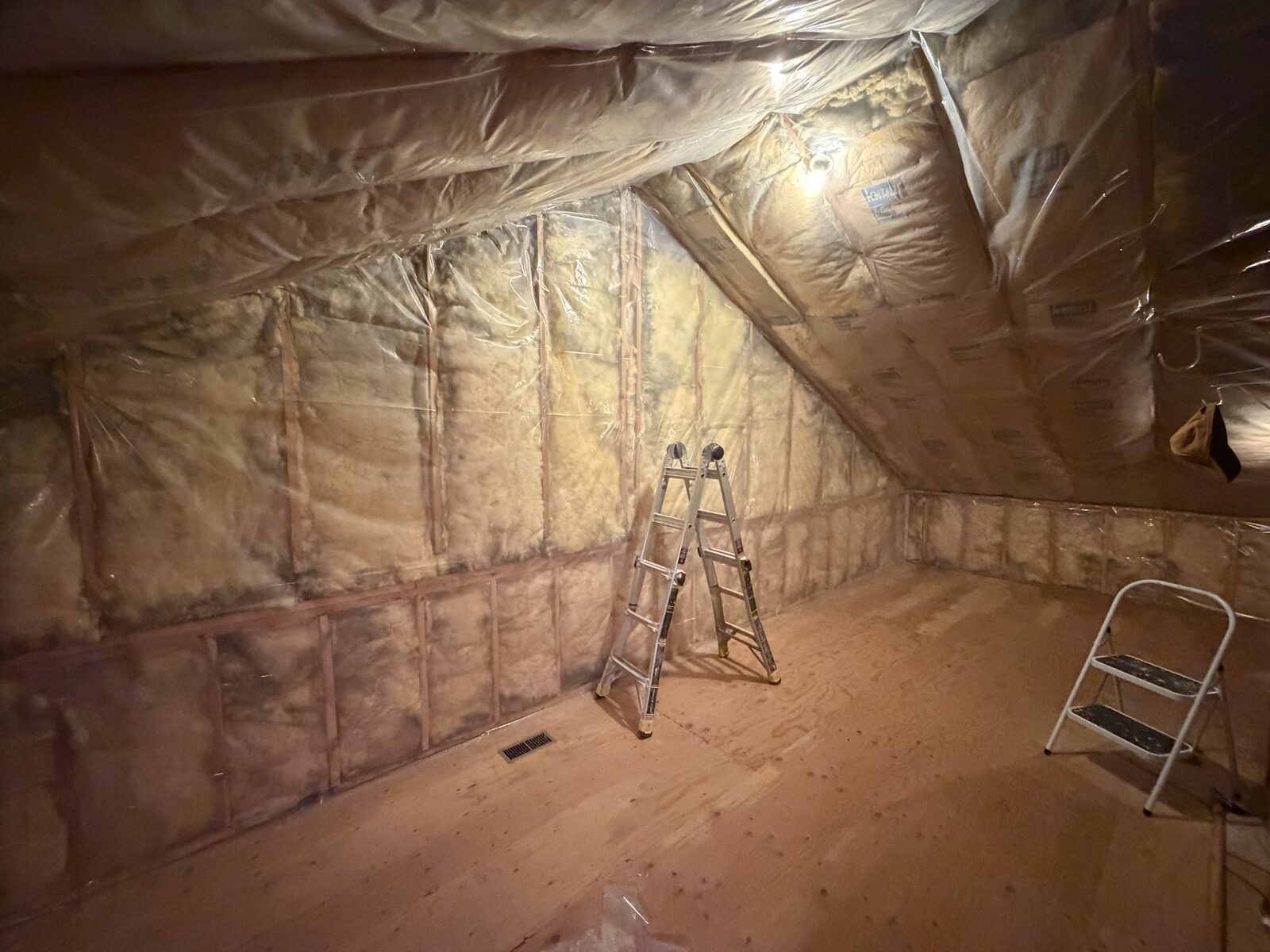 Attic space with framed knee walls, fiberglass insulation and vapor barrier installed ready for drywall