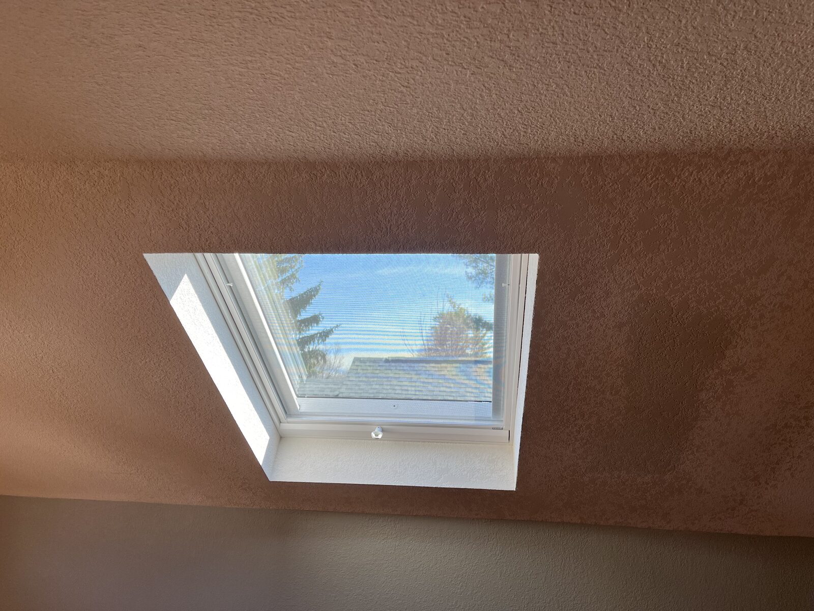 Skylight opening in a textured ceiling with the shaft drywalled, taped and texture matched to the surrounding surface